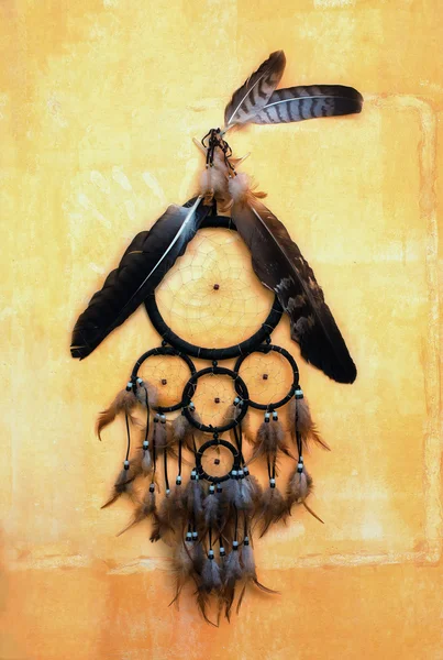 Atrapasueños con plumas de águila y cuervo en pared de estructura naranja. —  Fotos de Stock