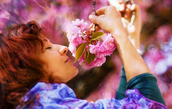 Hermosa chica con flores, magia de primavera. Sakura flores rosadas —  Fotos de Stock
