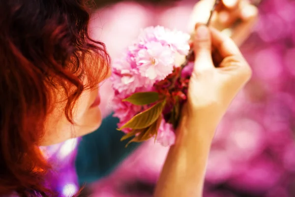 美しい桜の花、紫色の花の香りの若い女性。春の魔法 — ストック写真