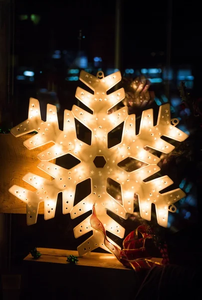 Glanzende elektrische Kerstmis sneeuw vlok symbool, op donkere nachtelijke achtergrond — Stockfoto