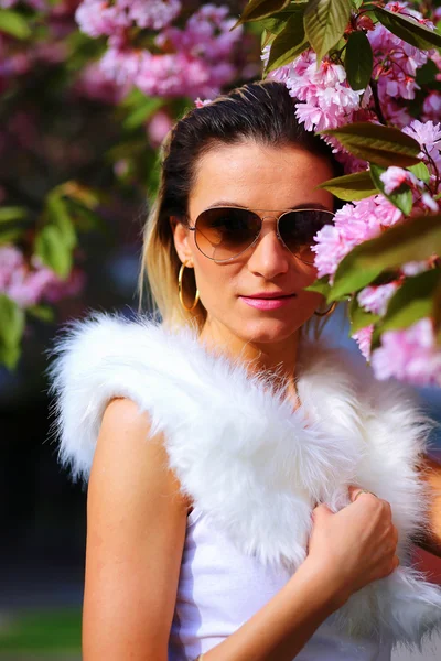 Beautiful Girl with flowers, Spring Magic. Sakura pink flowers. With glamour white fur, and sunglasses — Stock Photo, Image