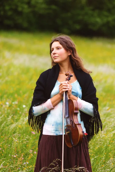 Violoniste sur une prairie pleine de fleurs, Jeune fille jouant de l'instrument de musique — Photo