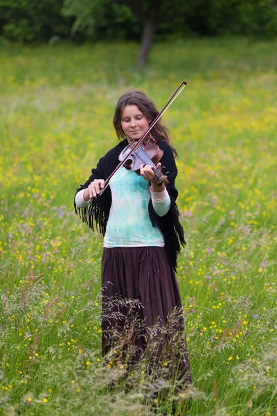 Violoniste sur une prairie pleine de fleurs, Jeune fille jouant de l'instrument de musique — Photo