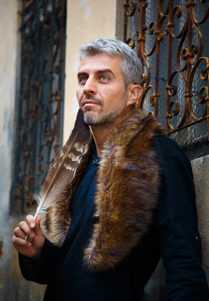 Portrait d'un homme sexy et loup à poils et plumes d'aigle, et fenêtre médiévale ornementale sur fond . — Photo