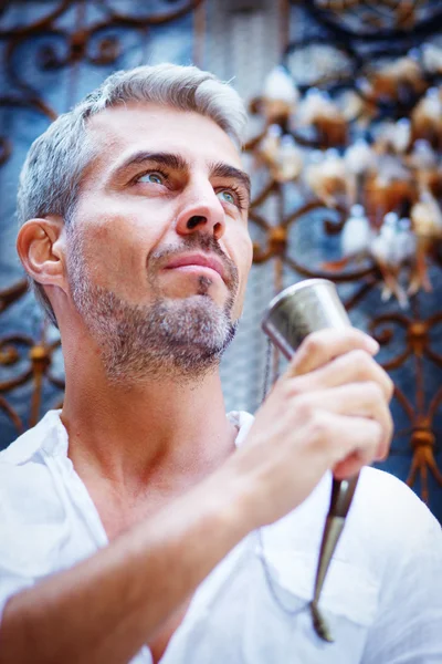 Sexi Man in a white shirt and medieval mead horn in hand. Ornamental window on background, and Dream Catcher. Toast concept — Stock Photo, Image