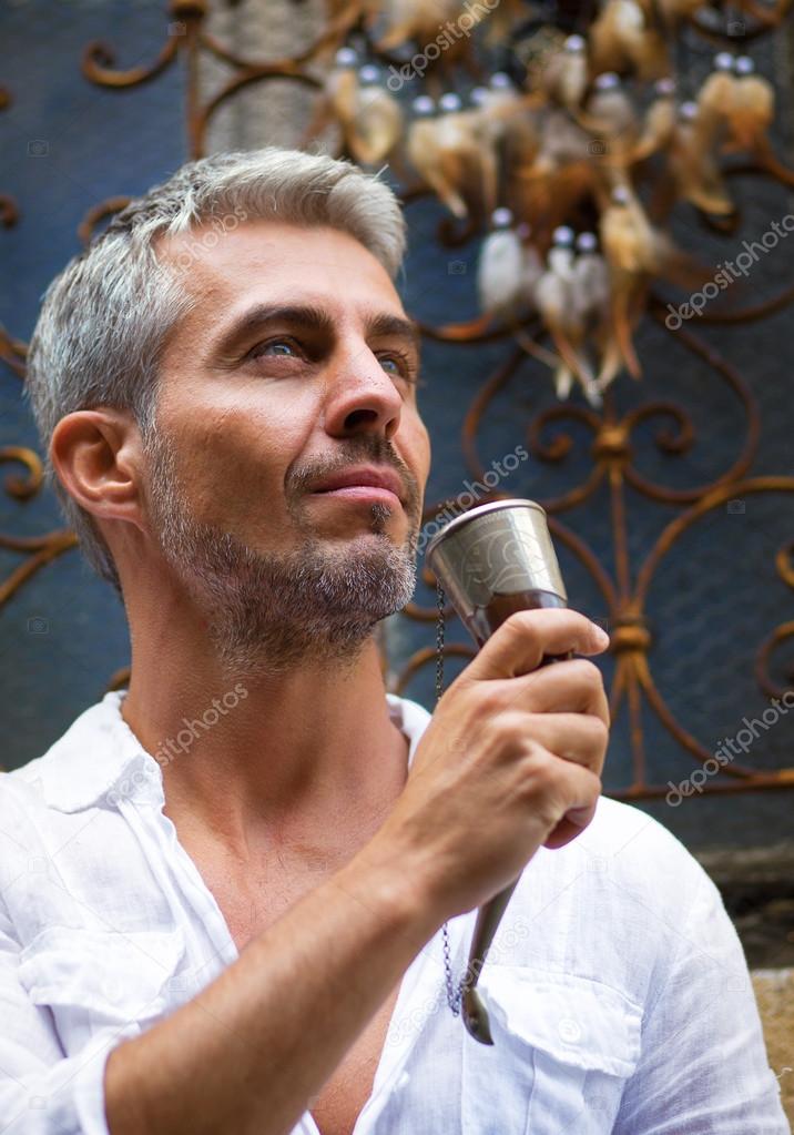 Man drinking beer  and medieval mead horn in hand. Toast concept