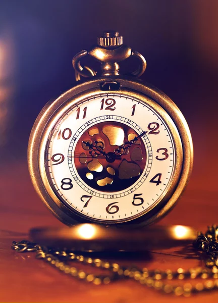 Reloj de bolsillo retro de oro con hermosa vela ligera sobre fondo marrón —  Fotos de Stock