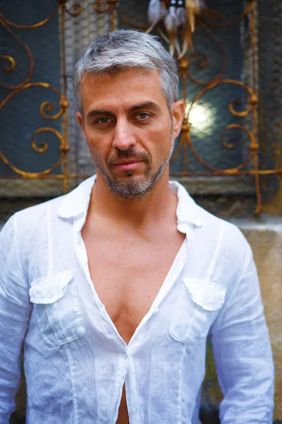 Homem em uma camisa branca e janela medieval ornamental no fundo . — Fotografia de Stock