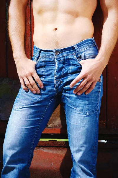 Сексуальний портрет моди гаряча чоловіча модель в стильних джинсах з м'язистим позуванням тіла . — стокове фото