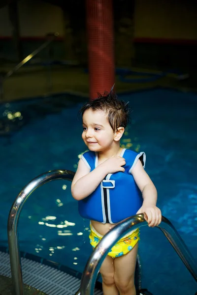 男孩在与充气游泳背心、 一个室内游泳池池 — 图库照片