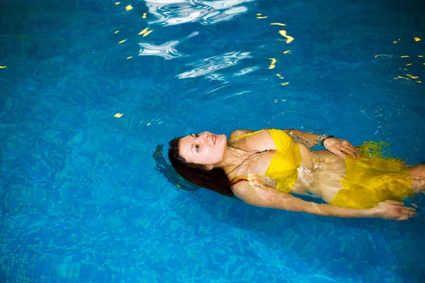 Портрет молодой женщины, отдыхающей в бассейне. купаться в бассейне и жёлтом купальнике. Копирование пространства . — стоковое фото