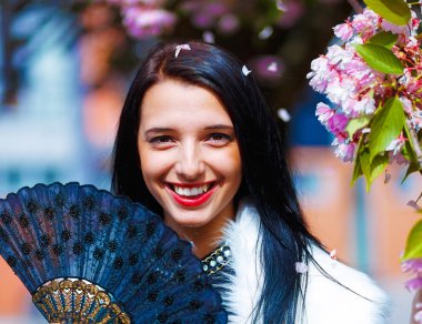 Güzel bir sakura çiçeği kokan genç bir kadın, mor çiçekler. Bahar Büyüsü.