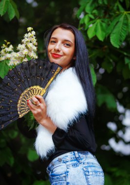 Smiling young woman smelling a beautifull Spring Magic, and beautiful ornamental fan. Flower background.