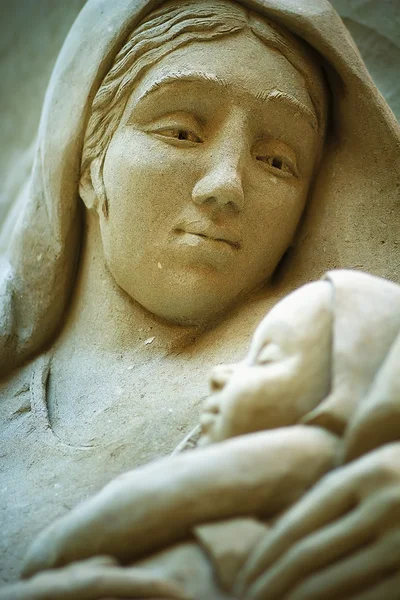 Madonna with baby Jesus sculpted in stone . — Stock Photo, Image