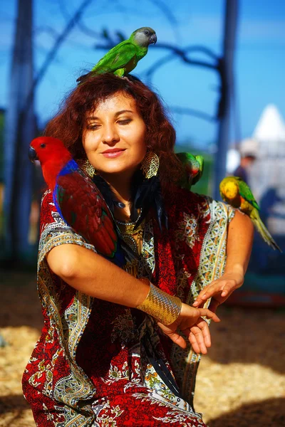 Młoda kobieta w ozdobnych sukienka i piękna Biżuteria złota z papug kolor — Zdjęcie stockowe