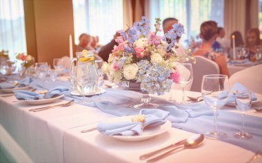 Zarif masa dekorlu günışığı ziyafeti odası güzel çarşaflar ve hafif ışıklandırmayla romantik kutlama sahnesi.