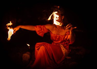 Büyüleyici bir ateş dansçısı, performans sırasında büyüleyici alevler konusundaki yeteneğini güzel bir şekilde sergiliyor.