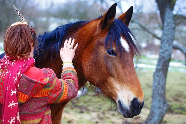 Mulher retrato e cavalo ao ar livre. mulher abraçando um cavalo e tem pena no cabelo — Fotografia de Stock
