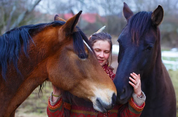Mulher de retrato e cavalos ao ar livre. Mulher abraçando um cavalo e tem pena no cabelo — Fotografia de Stock