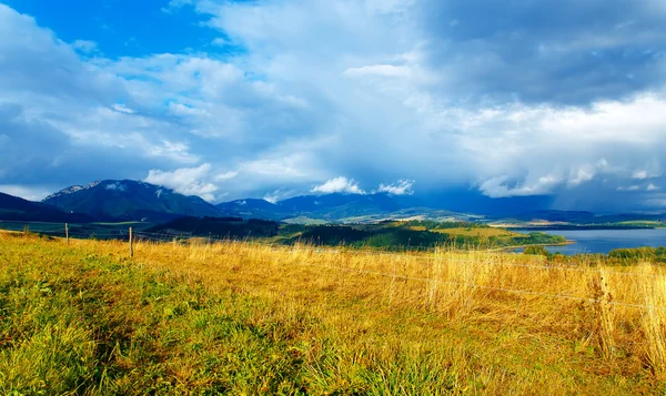 Beau paysage, prairie verte et jaune et lac avec montagne en arrière-plan. Slovaquie, Europe centrale. — Photo