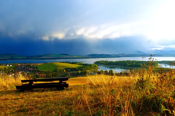 Beau paysage, lac avec village. Assise donnant sur le paysage . — Photo