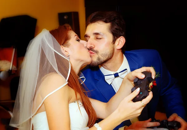 Bride and groom playing together videogames with joysticks - gaming and wedding concept. — Stock Photo, Image