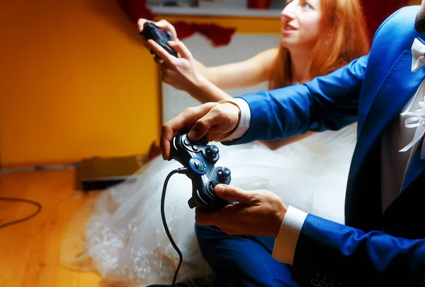 Наречений і наречений грають разом відеоігри з джойстиками - ігрова та весільна концепція . — стокове фото