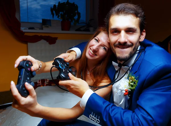 Sposa e sposo che giocano insieme videogiochi con joystick - concetto di gioco e matrimonio . — Foto Stock