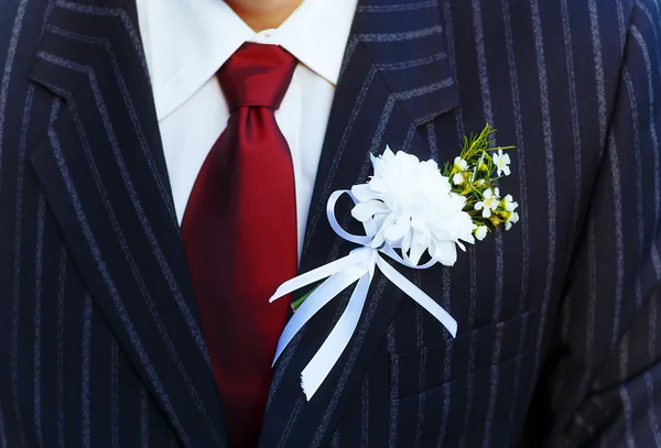 Primer plano negro chaqueta novio en su boda día con una corbata roja y solapa ojal . —  Fotos de Stock