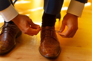 evde kahverengi Düğün Ayakkabı üzerinde koyarak damat.