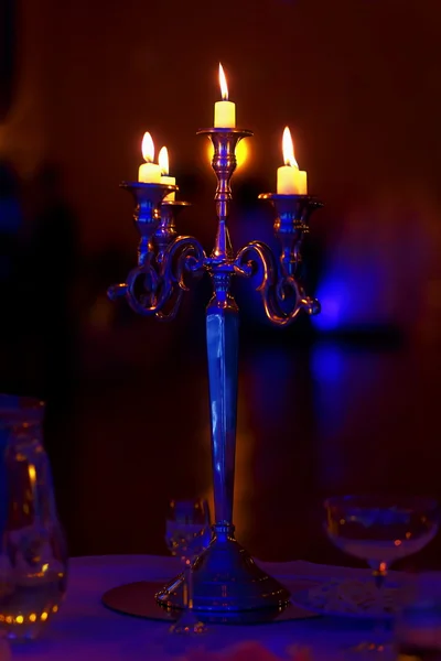 Lustre de prata e velas em chamas na mesa de casamento decorada . — Fotografia de Stock