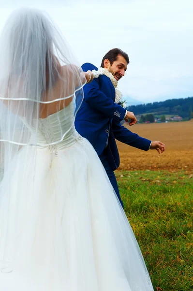 Noiva puxando seu noivo para ela com uma corda conceito de casamento engraçado . — Fotografia de Stock