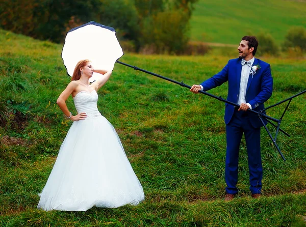 Braut posiert mit Fotoausrüstung in der Landschaft für ihren Bräutigam. — Stockfoto