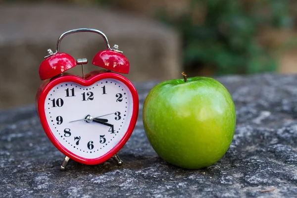 Clock and red apple — Stock Photo, Image