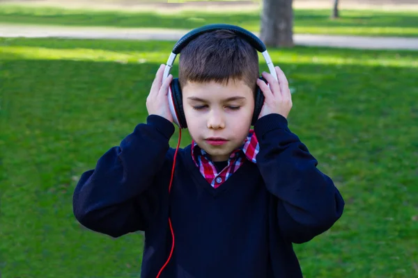 ヘッドフォンの少年が音楽と目を閉じて聴いてください。 — ストック写真