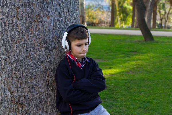 Ragazzo su un albero che ascolta musica — Foto Stock