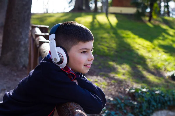 Beau garçon avec écouteurs admire la nature — Photo