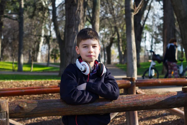 Szép fiú a parkban, a fejhallgató — Stock Fotó