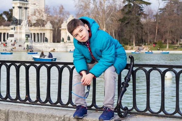 Ragazzo alla moda seduto in una giacca blu — Foto Stock