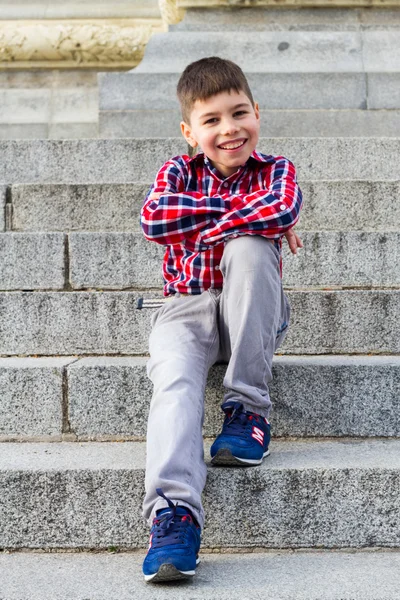 Ragazzo in jeans seduto sulle scale — Foto Stock