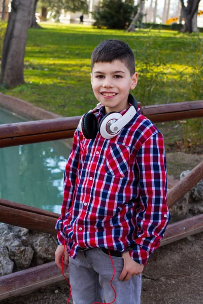 Ragazzo in piedi nel parco e sorridente — Foto Stock