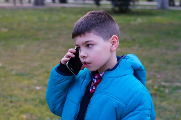 A fiú kék kabát, beszél a telefonon — Stock Fotó