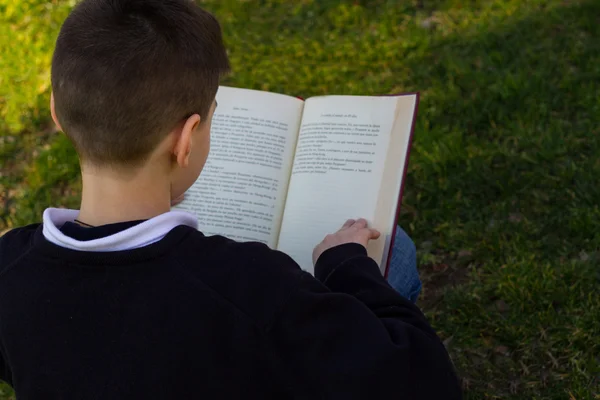 Jongen zittend op het gras — Stockfoto