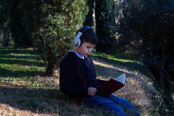 少年は公園で座って本を読んで — ストック写真