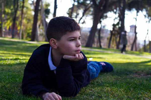 Chlapec na trávě někde při pohledu — Stock fotografie