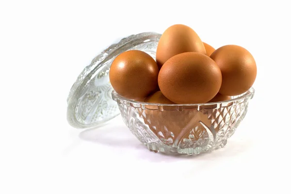 Chicken eggs in a glass bowl on a white background — Stock Photo, Image