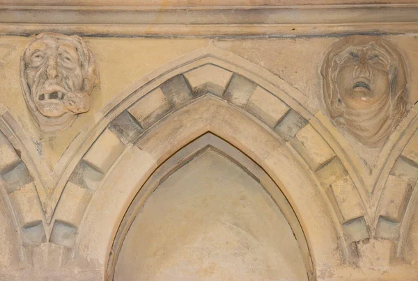 Garip duvarlarla çevrili bir kapı ve acı ve ıstırapla dolu kadim garip yüzler. Ortaçağ taş duvarı duygularını gösterir. Soyut erkek ve kadınlar acı ve hastalık çekiyor. Tapınak Kilisesi, İngiltere