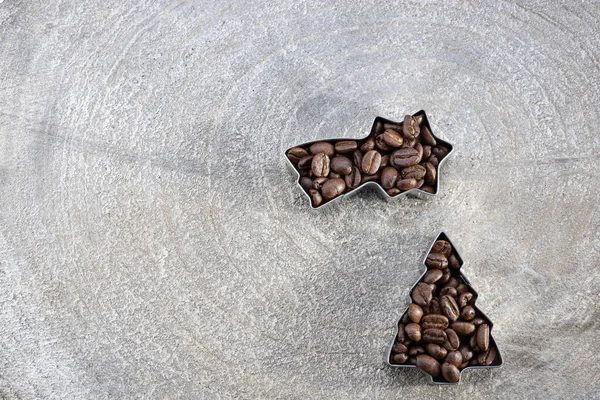 Noel için bir kartpostal şablonu içinde kahve çekirdekleri olan gri ahşap dilimli, kayan yıldız şekilli ve Noel ağacı ve metin alanının fotokopi makinesine doldurulmuş.