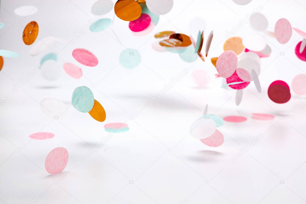 falling confetti in rose, mint and pink colors made of large silk paper circles on white background with light shadows.