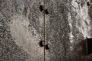 Almanya 'da terk edilmiş bir sanayi bölgesindeki vidalar ve fındıklar ile sert ve paslı bir metal yüzeyi yakından çek.